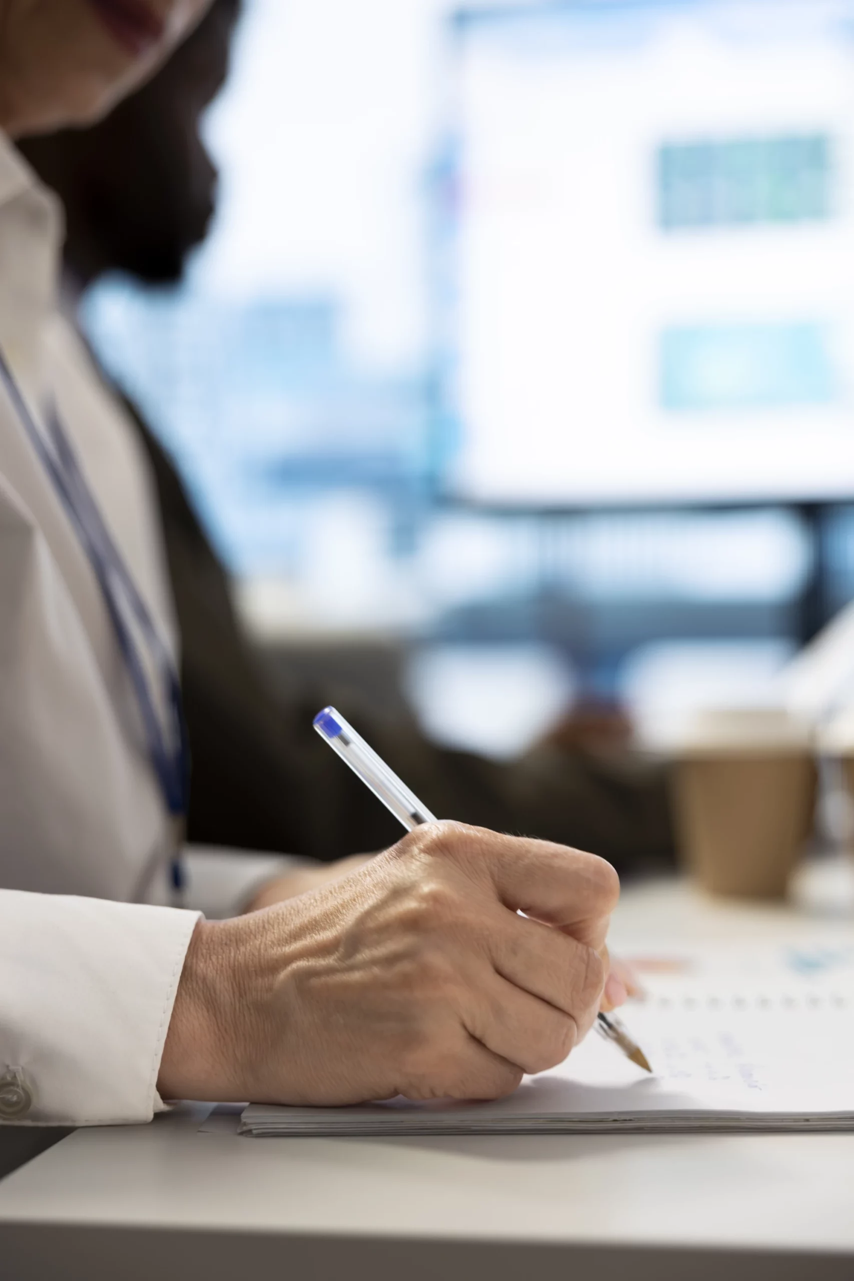 Das Bild zeigt eine Frau, die sich Notizen zur Prozesszeitoptimierung und LEAN-Management macht